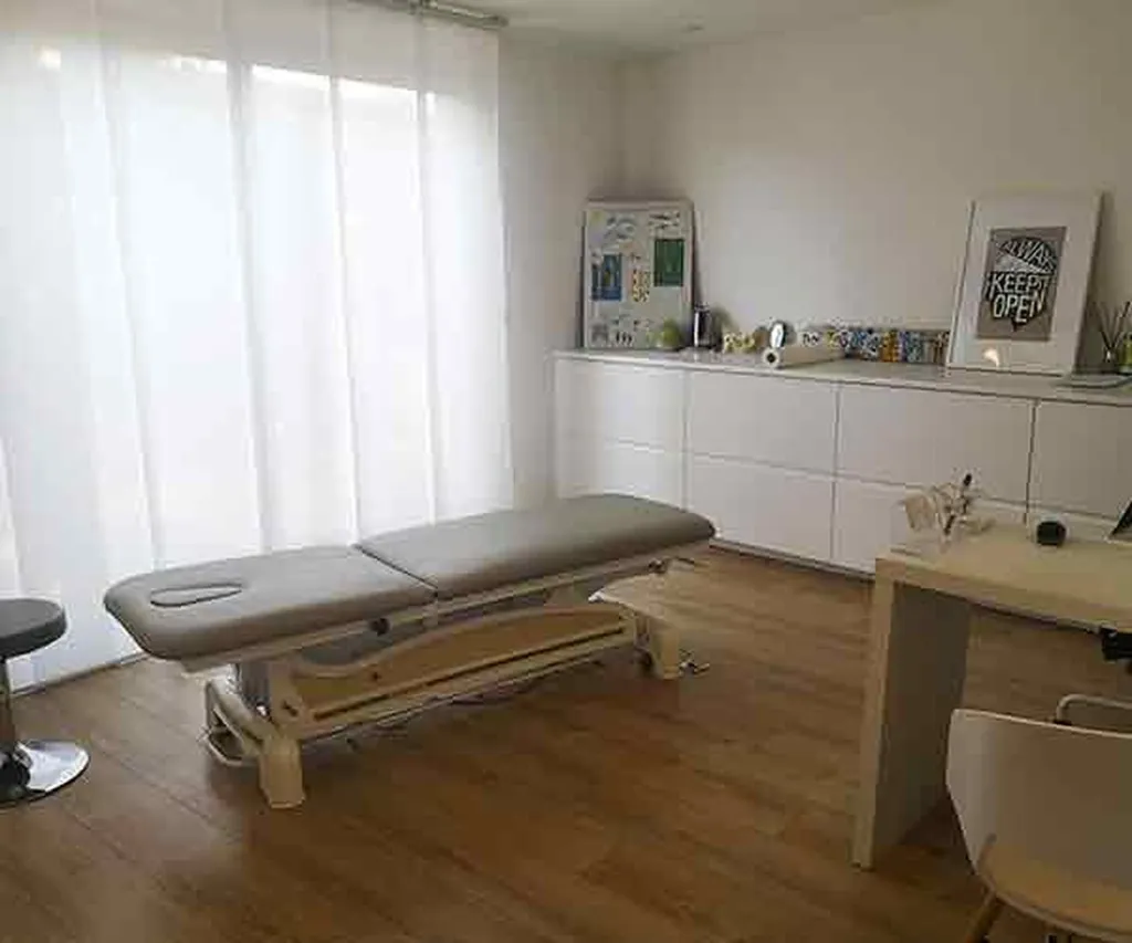 Salle de consultation lumineuse avec la table d’ostéopathie